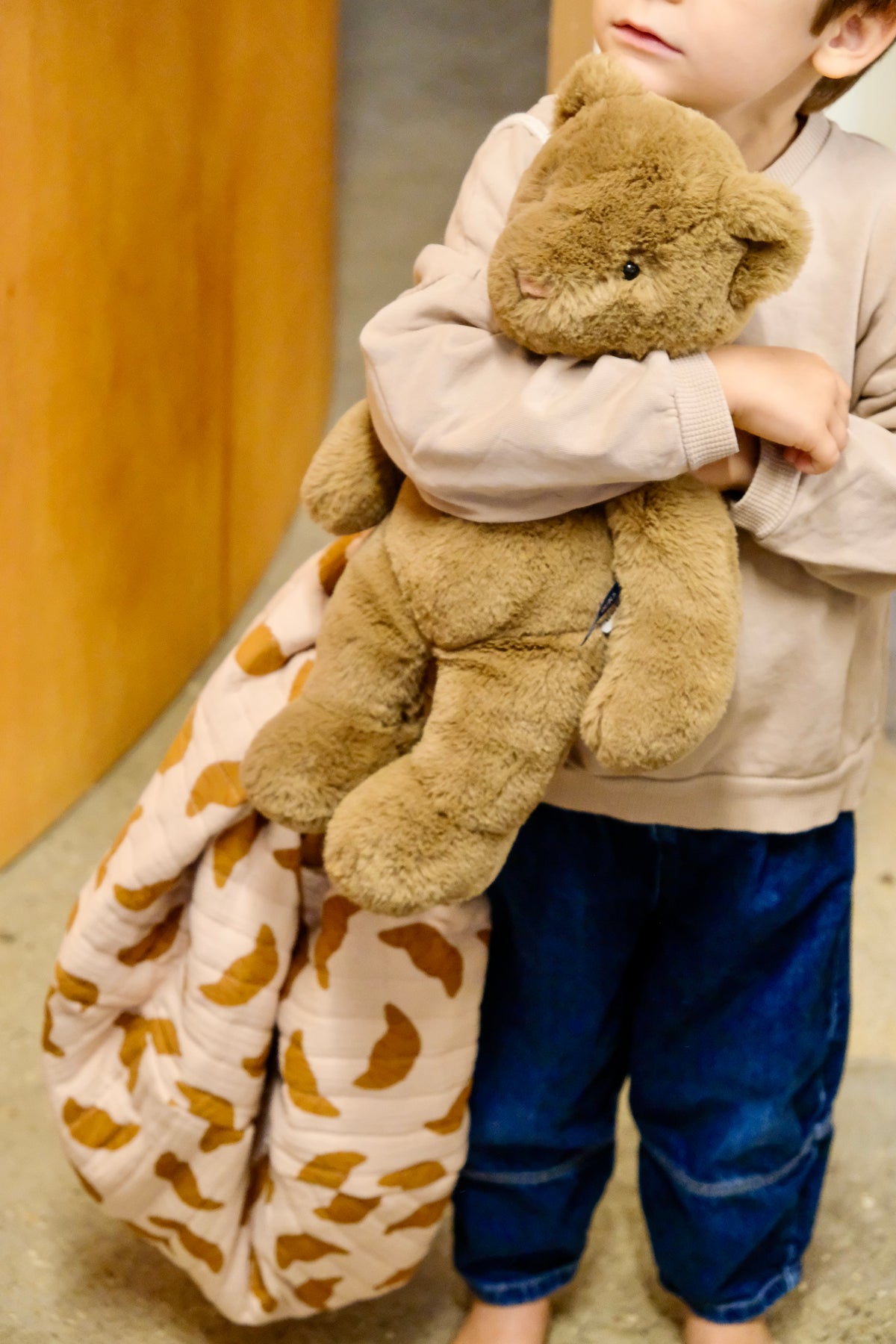 enfant tirant un nid bag croissant avec une peluche dans les bras
