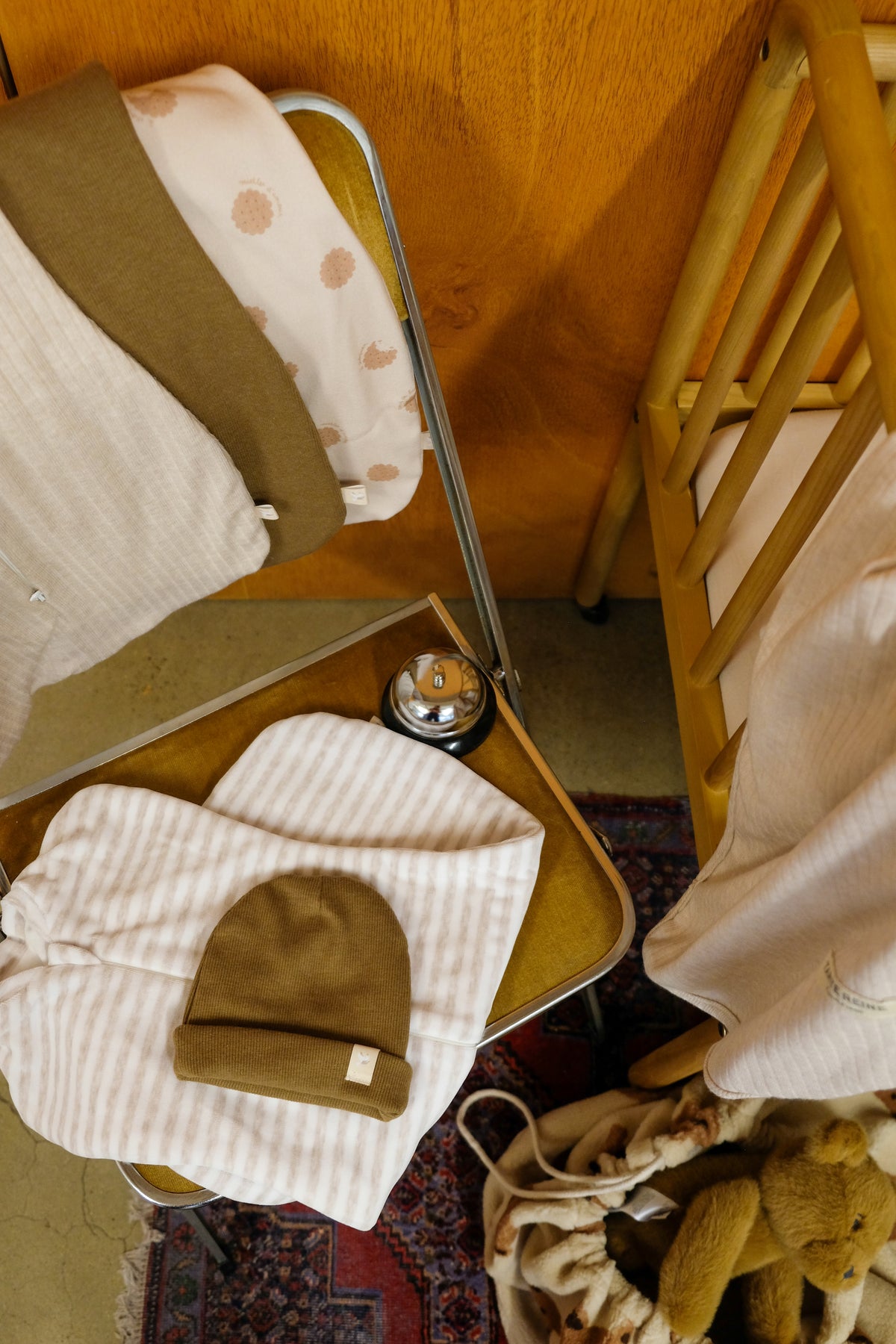 Emmailloteuses posées sur une chaise avec bonnet de naissance noisette
