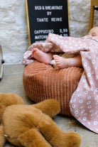 pieds de bébé sur nid cannelle avec couverture guimauve