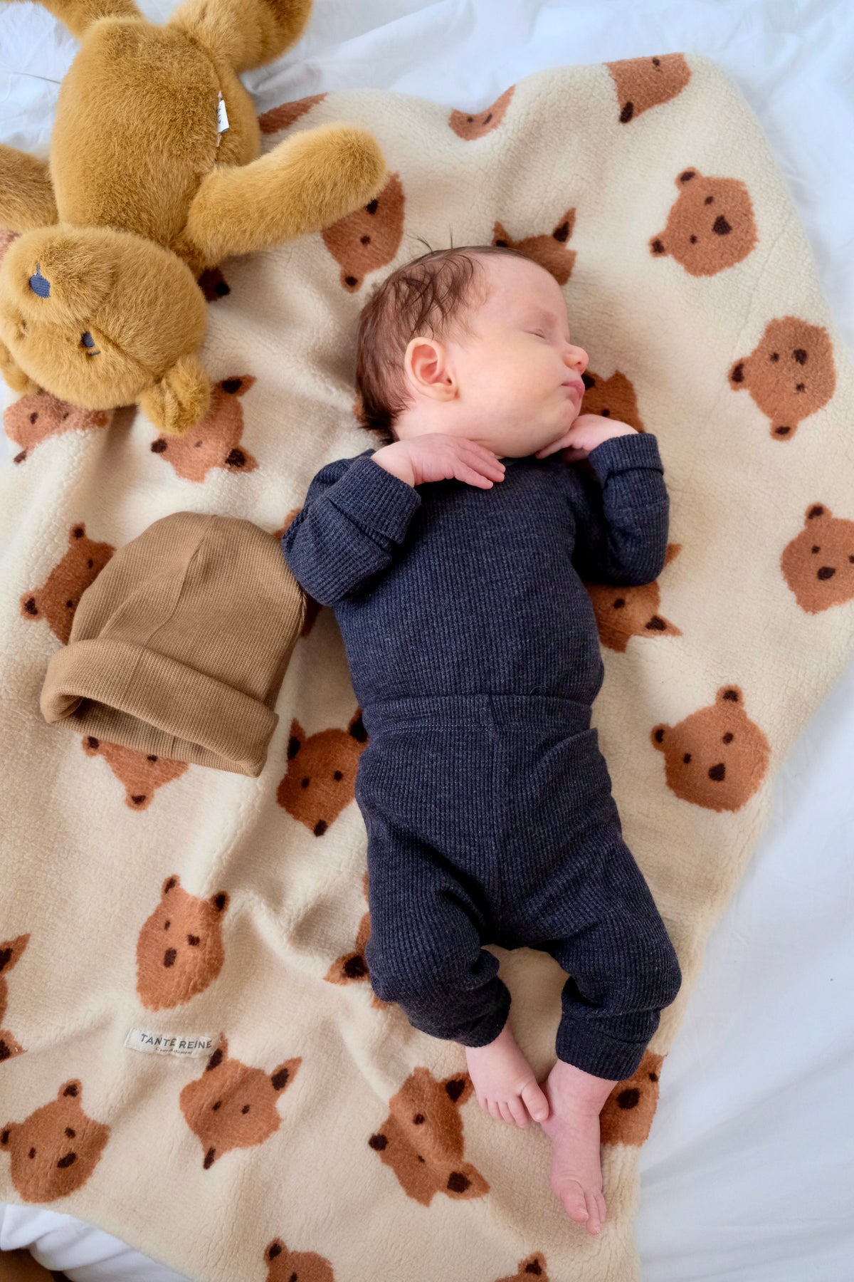 bébé sur couverture renards et oursons avec bonnet