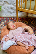 Bébé posé sur nid cannelle avec couverture guimauve et bonnet de naissance