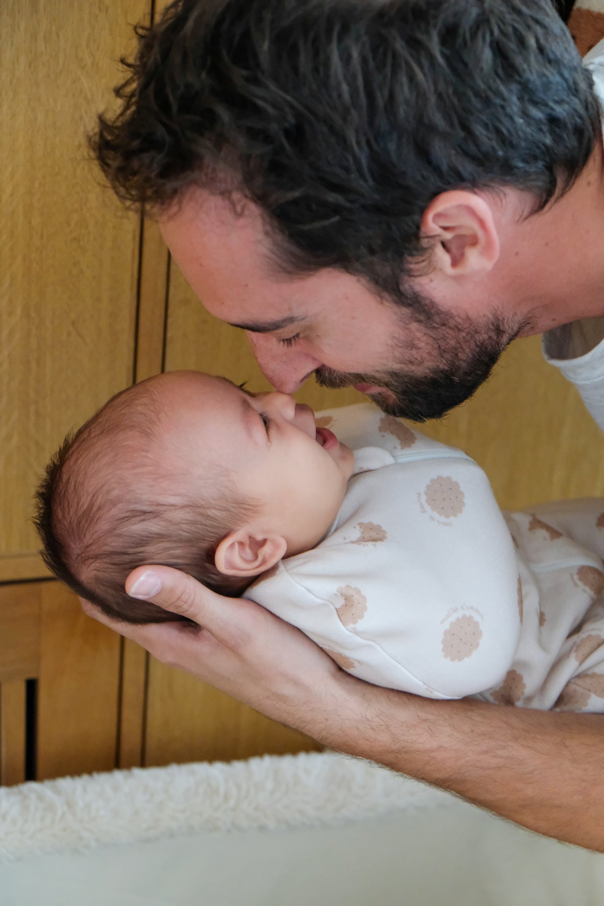 papa regardant son bébé emmailloté