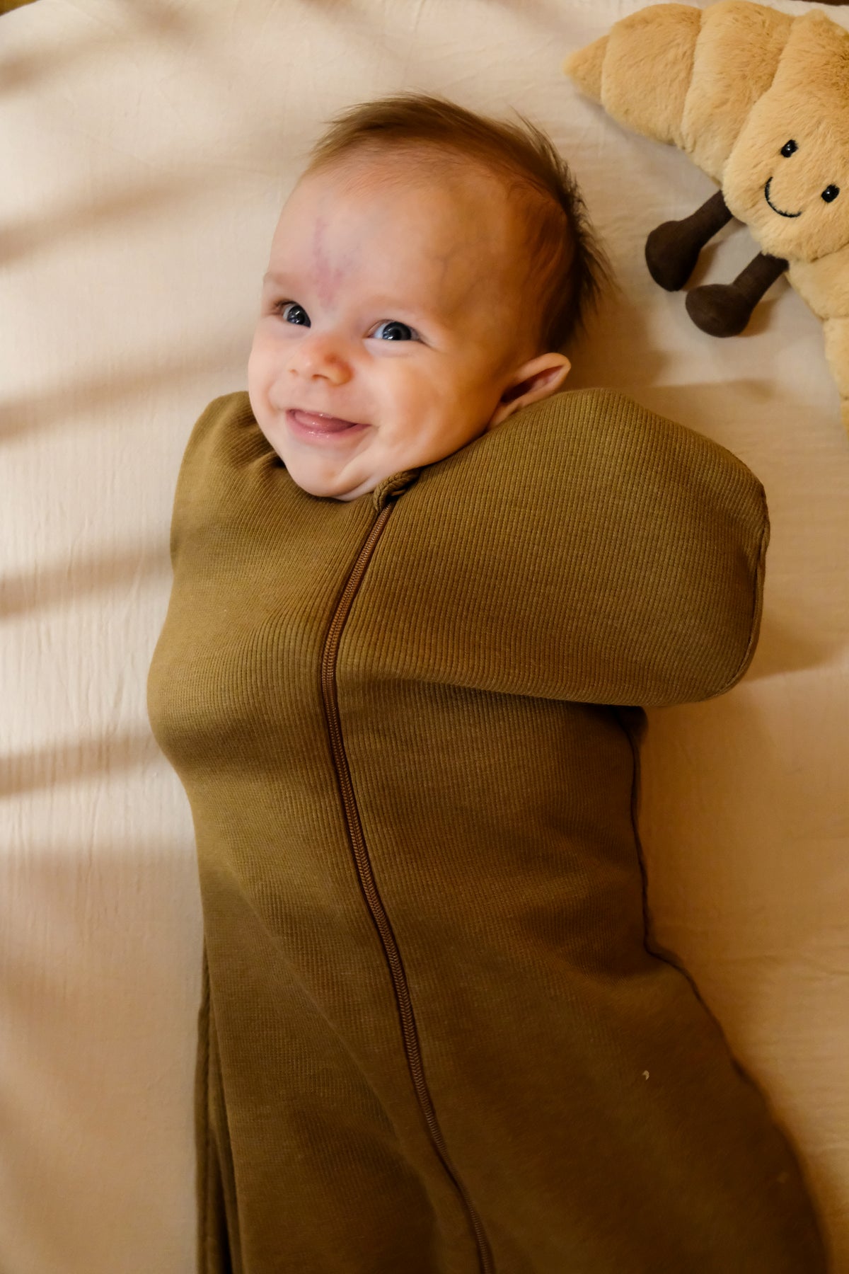 bebe emmailloté qui sourit