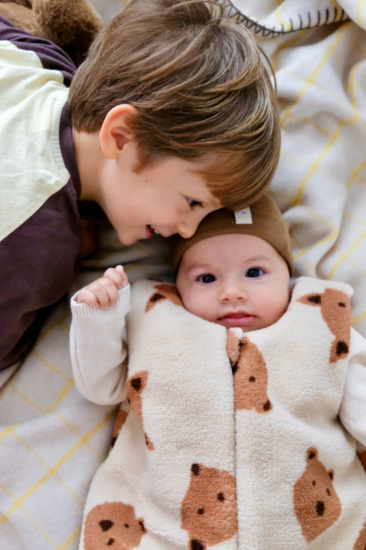 enfant et bebe complices avec bebe en gigoteuse oursons et renards
