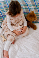 enfant dans gigoteuse à pieds cookie sur un lit